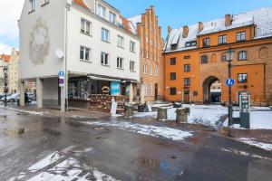 una calle de la ciudad con nieve en el suelo y edificios en Warzywnicza Apartment Motława River by Renters en Gdansk