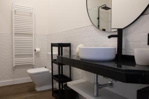 uma casa de banho com um lavatório, um WC e um espelho. em Costanilla Turismo em Zamora