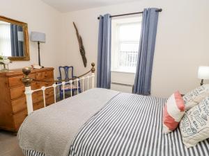 1 dormitorio con cama y ventana en Driftwood Apartment, en Amble