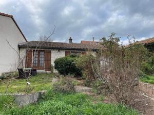 an old house with a yard with weeds in front of it at May's Cottage in Availles-Limouzine