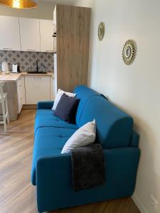 um sofá azul sentado numa sala de estar em Marianne 1 em Bergerac