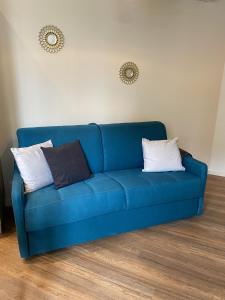 um sofá azul numa sala de estar com duas almofadas em Marianne 1 em Bergerac