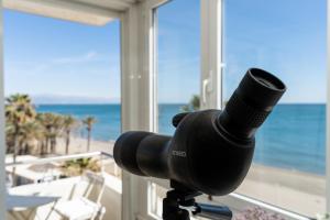 uma câmara num tripé com vista para o oceano em MONKÓ ON THE ROCK em Torremolinos