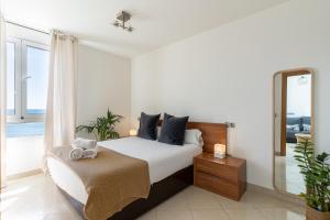 ein Schlafzimmer mit einem großen Bett und einem Spiegel in der Unterkunft MONKÓ ON THE ROCK in Torremolinos