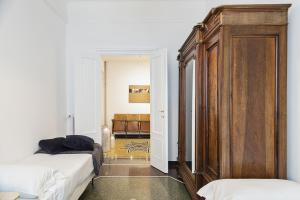 a bedroom with two beds and a large wooden cabinet at Beauty & Design in the Center by Wonderful Italy in Genova