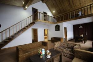 ein Wohnzimmer mit einem Sofa, einem Tisch und einer Treppe in der Unterkunft Shivalik kanyal cottage in Manali + 3 Fotos