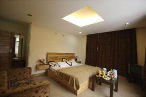 ein Schlafzimmer mit einem Bett, einem TV und einem Sofa in der Unterkunft Shivalik kanyal cottage in Manali