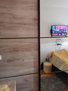 a bedroom with a wooden wall with a tv on it at Zgrada, stan in Kruševac
