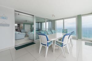 a dining room with a table and chairs and the ocean at CAPRI 15 in Margate