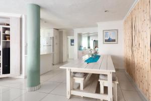a white kitchen with a table and a green pole at CAPRI 15 in Margate
