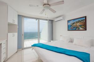 a white bedroom with a bed and a large window at CAPRI 15 in Margate