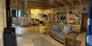 ein Wohnzimmer mit einem Sofa und einer Küche in der Unterkunft Gites Le Bois de l'Eglise in Villiers-le-Roux
