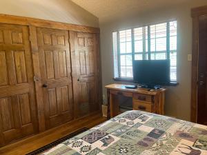 a bedroom with a bed and a flat screen tv at Casa Nueva #5 Townhouse With Wifi in Red River