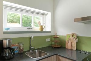 a kitchen counter with a sink and a window at Vakantieverblijf de Trommel in Domburg