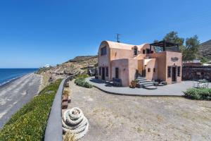 a large house on the side of a beach at Ramni House: Private Villa with pool by the Sea in Oia