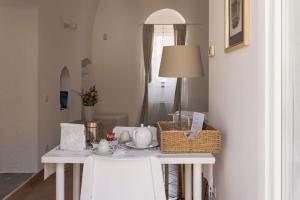 einen weißen Tisch mit einem Korb darüber in der Unterkunft Il Vicinato, casa vacanza immersa nel cuore dei Sassi in Matera