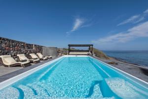 a swimming pool with a view of the ocean at Ramni House: Private Villa with pool by the Sea in Oia