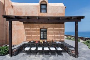 a patio with a table and chairs under a building at Ramni House: Private Villa with pool by the Sea in Oia