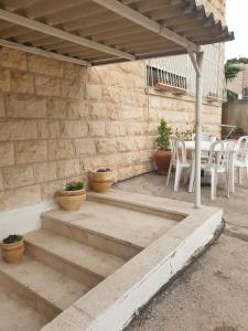 un patio con escaleras, mesa y sillas en Studio E-Sheikh en Jerusalén