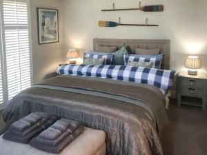 a bedroom with a large bed with blue and white pillows at The Coach House in Whitstable