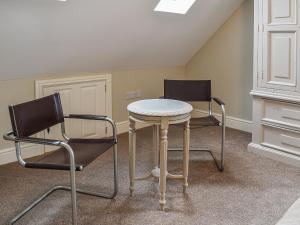 2 sillas y una mesa en una habitación en The Coach House, en Whitstable