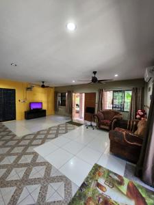 ein Wohnzimmer mit Sofas und einem Flachbild-TV in der Unterkunft OYO HOME 90751 Jasura Lodge Kiulu in Tamparuli