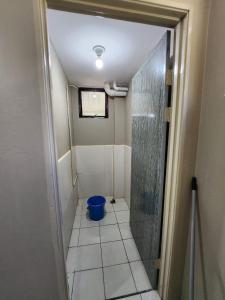 ein Badezimmer mit einer Dusche und einem blauen Eimer in der Unterkunft OYO HOME 90751 Jasura Lodge Kiulu in Tamparuli