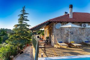 Casa con terraza con mesa y sombrilla en Villa Kleio, en Kámboi