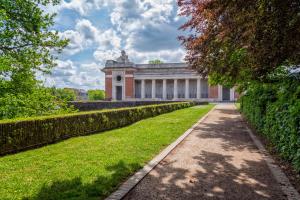 a building with a pathway in front of a yard at Maison Rose in Ypres