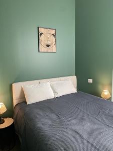 1 dormitorio con 1 cama con pared azul en Marianne 5, en Bergerac