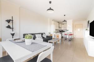 een witte woonkamer met een tafel en een bank bij Home2Book Stylish&Comfy Apartment Rambla, Terrace in Las Palmas de Gran Canaria