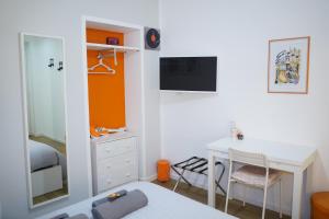 una camera da letto con scrivania, letto e specchio di B&B Arts And Music ad Ancona