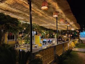 a restaurant with people sitting at a bar at night at Elephant Pushkar in Pushkar