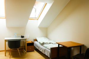 a bedroom with a bed and a desk and a window at Dom Studenta PANS - Akademik, Hostel in Przemyśl