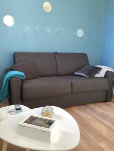 uma sala de estar com um sofá e uma mesa de café branca em Marianne 4 em Bergerac