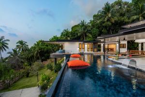 basen bez krawędzi z pomarańczowym parasolem w domu w obiekcie Infinity villa 600 M2 sea view w mieście Haad Yao