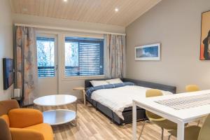 Schlafzimmer mit einem Bett, einem Tisch und Stühlen in der Unterkunft Pyhä Snowflake in Pyhätunturi