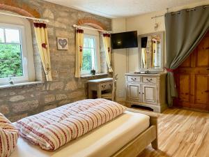 a bedroom with a bed and a stone wall at Land & Leben Pension in Chemnitz