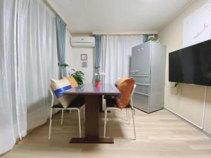 Habitación con mesa, sillas y TV. en D27-Outstanding convenience 4DK/ Shinjuku Okubo en Tokio