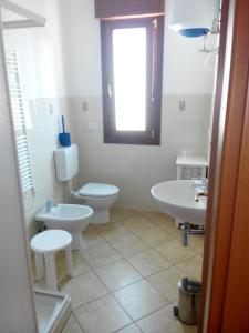 a bathroom with two sinks and a toilet and a window at Ada Home in Sanremo