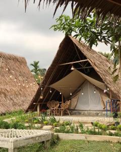 a tent with chairs and tables in front of it at Tangkahan Eco Glamping 