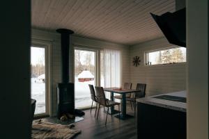 a dining room with a table and chairs and windows at Överkalix Jockfall Holiday Home in Jock