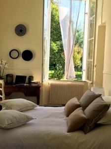 łóżko z poduszkami w sypialni z oknem w obiekcie Domain de Montvert - 5 min from Saint Emilion w mieście Sainte-Terre +37 zdjęć