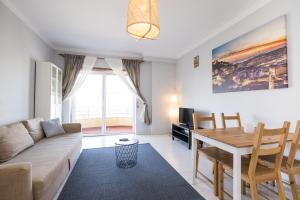 ein Wohnzimmer mit einem Sofa und einem Tisch in der Unterkunft Hoso Apartments T1 in Costa da Caparica