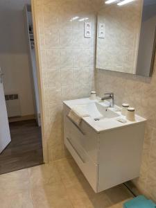 ein Bad mit einem Waschbecken und einem Spiegel in der Unterkunft Hotel Restaurant L'Escale in Sainte-Nathalène