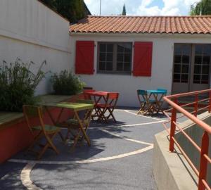un groupe de tables et de chaises devant une maison dans l'établissement Le Patio de la Madone, à Le Givre