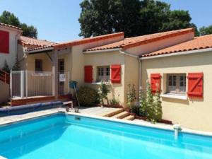 une maison avec une piscine en face d'une maison dans l'établissement Le Patio de la Madone, à Le Givre