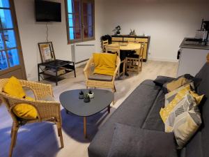- un salon avec un canapé, des chaises et une table dans l'établissement Le Patio de la Madone, à Le Givre