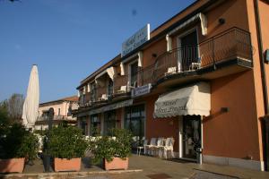 a building with chairs and plants in front of it at Hotel Moro Freoni in San Pietro in Cariano