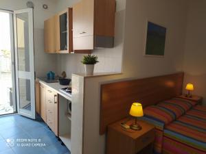 cocina pequeña con sofá y mesa con lámpara en mini Residence Samarcanda appartamenti en Porto Cesareo